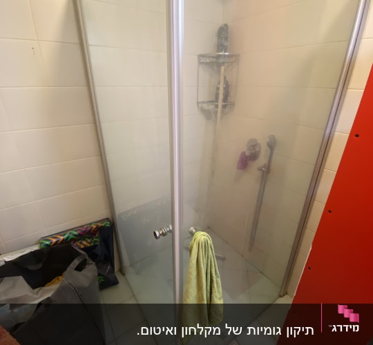 מקלחון עם מגבת ירוקה על הדלת